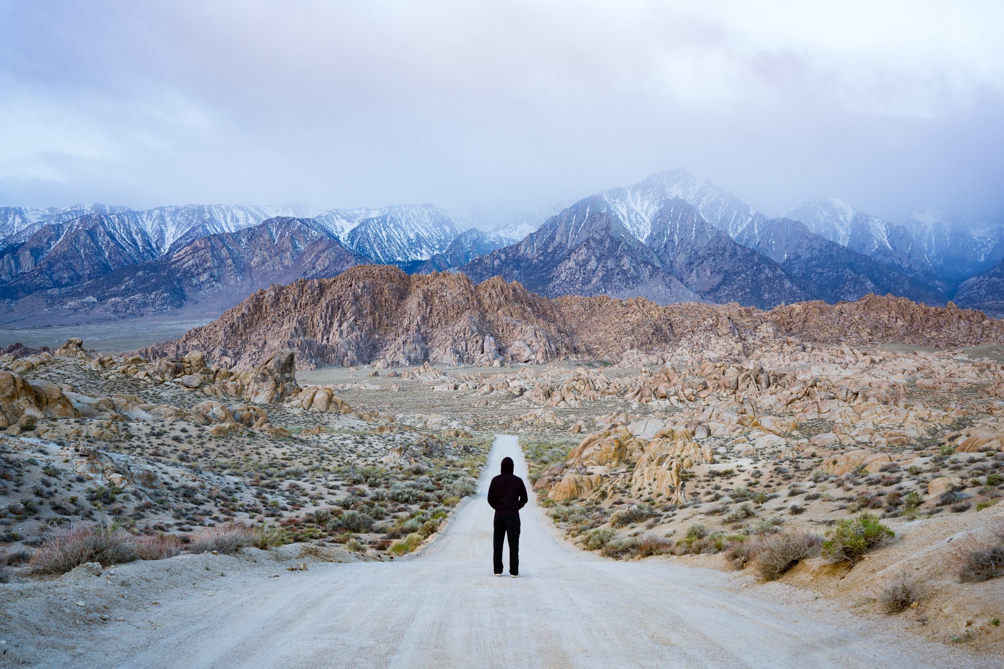 man on movie pass road in alabama hills during cloudy sunrise | photo by jake landon schwartz