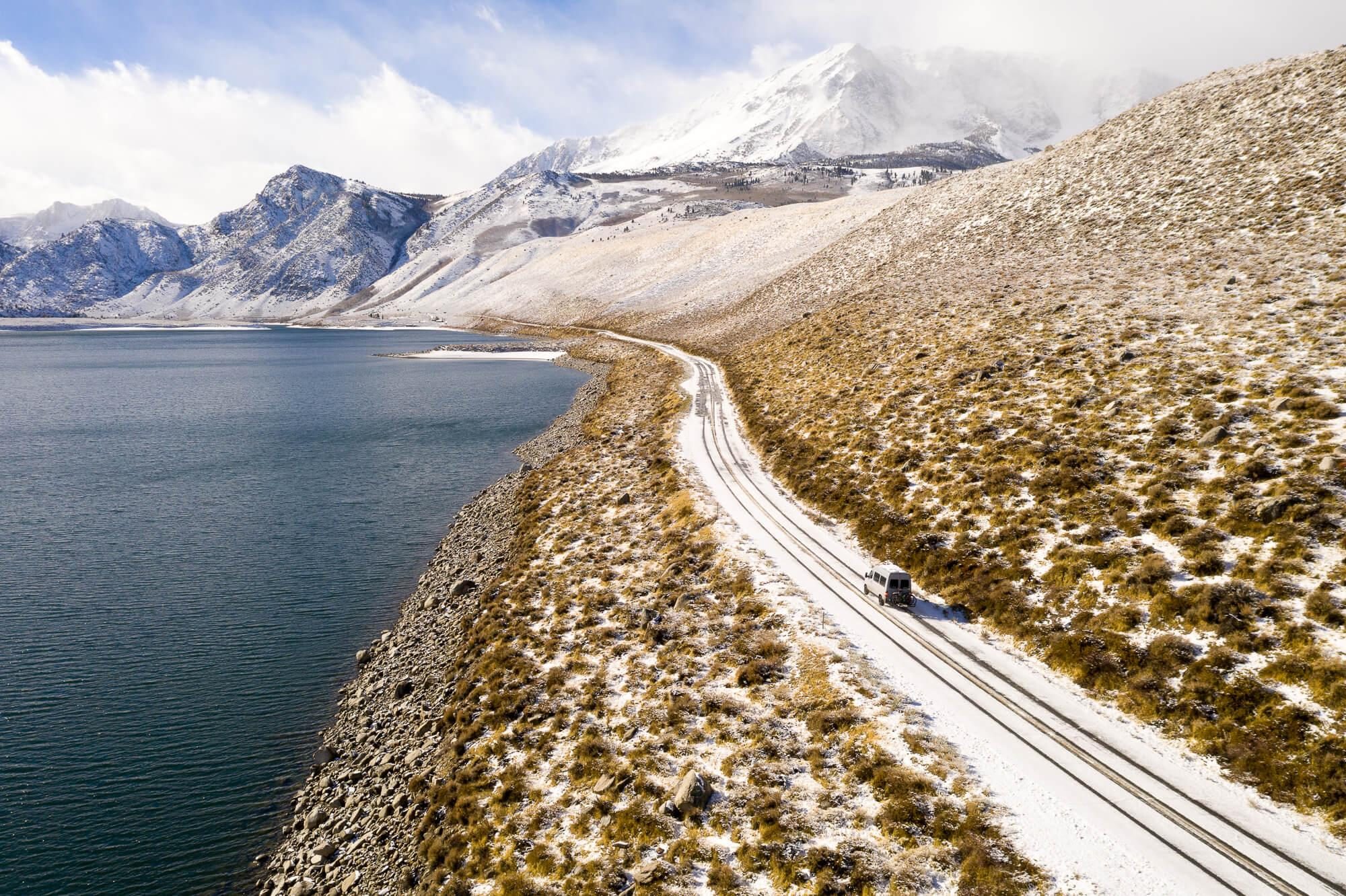 gray mercedes sprinter camper van driving along june lake loop in the eastern sierra nevada during winter | photo by jake landon schwartz