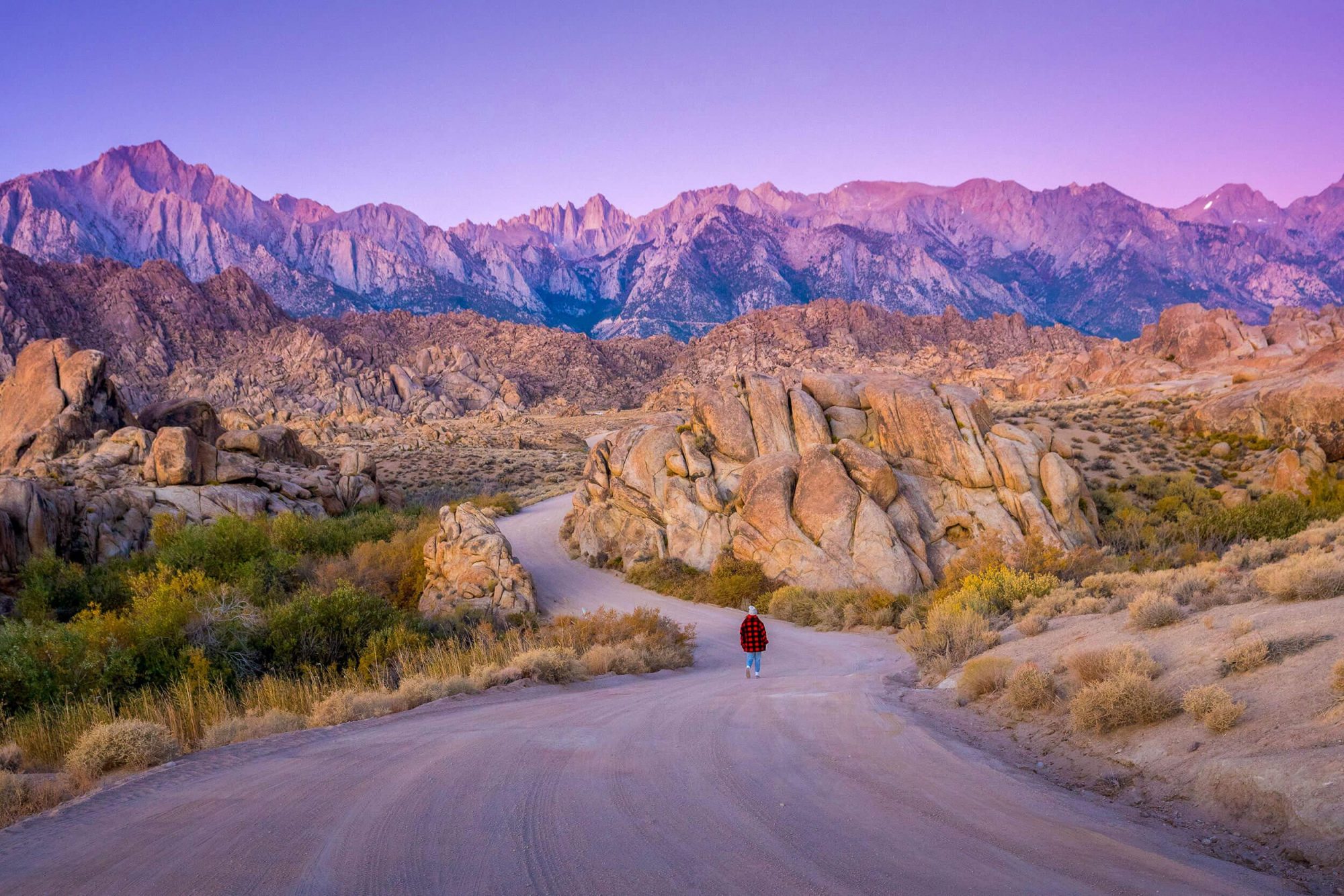 carly wallace walks down movie pass road in alabama hills near lone pine california as the sun rises on mt whitney and the eastern sierra nevada mountain range | photo by jake landon schwartz